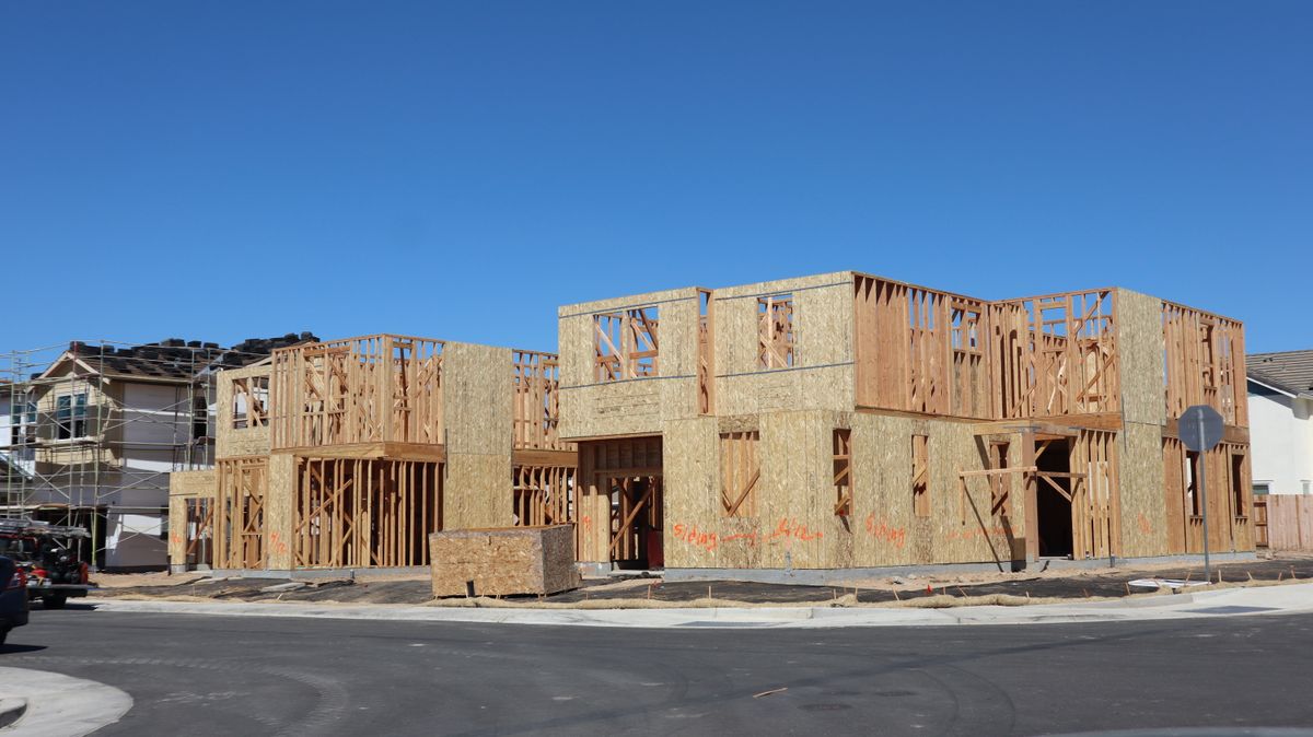 New two-story homes in wood framing and sheathing on a residential street