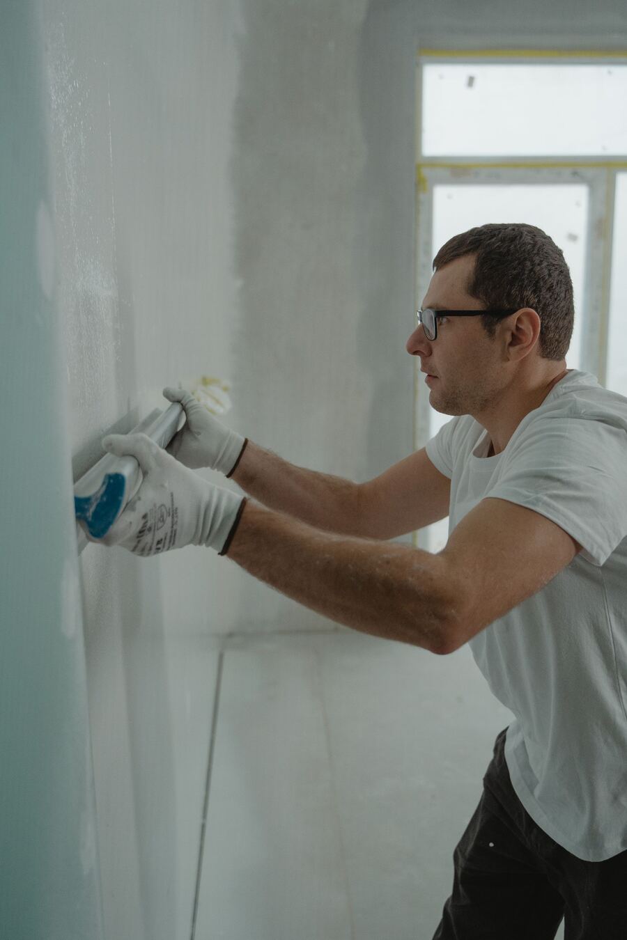 Worker finishing a drywall seam