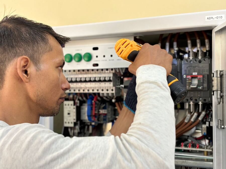 Electrician working inside an electrical panel