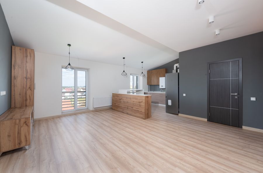 Newly finished open-plan interior with new plank flooring, fresh paint, and a new kitchen island
